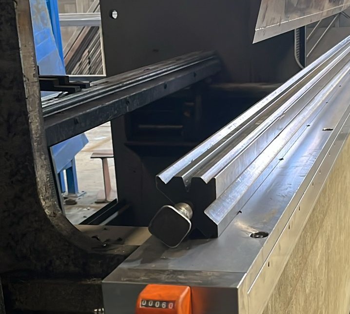 Vista lateral de la Mesa de Compensación de flexiones instalada en una plegadora AJIAL